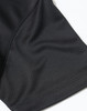A close-up of a black jacquard knit fabric, highlighting the texture and stitching details of a polo shirt.
