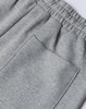A close-up of grey unisex sweatpants featuring an elastic waistband and a back pocket.