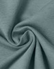 A close-up of soft, premium cotton fabric in a sage green colour, showcasing its texture and quality.