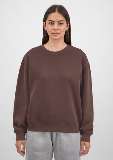 A brown crew sweatshirt for women, featuring a relaxed fit and long sleeves, displayed on a model.