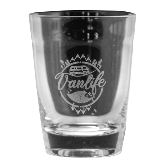 A glass carry cup with a clear design featuring an engraved logo related to van life, showcasing trees and a camper.