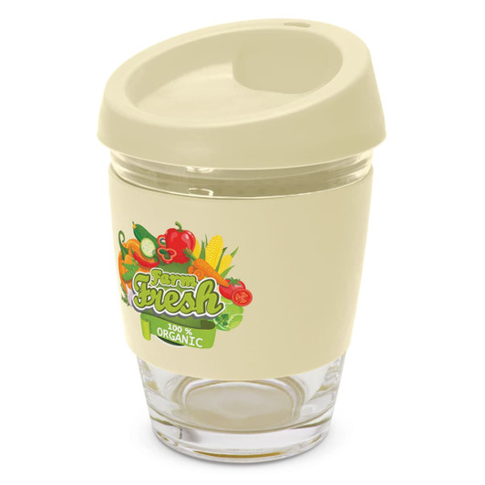A reusable coffee cup in cream with a transparent base and a silicone lid, featuring colourful vegetable graphics and a logo.