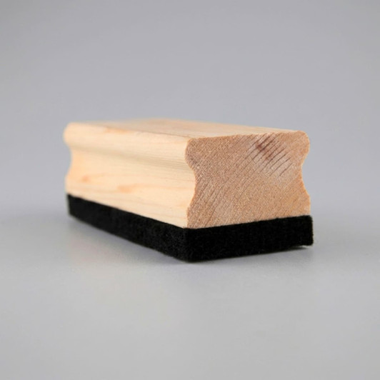 A wooden whiteboard eraser featuring a smooth wooden top and a black felt bottom.