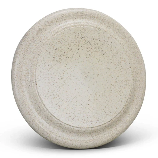 A large, speckled beige plate with a smooth surface and a raised edge, featuring a subtle logo.