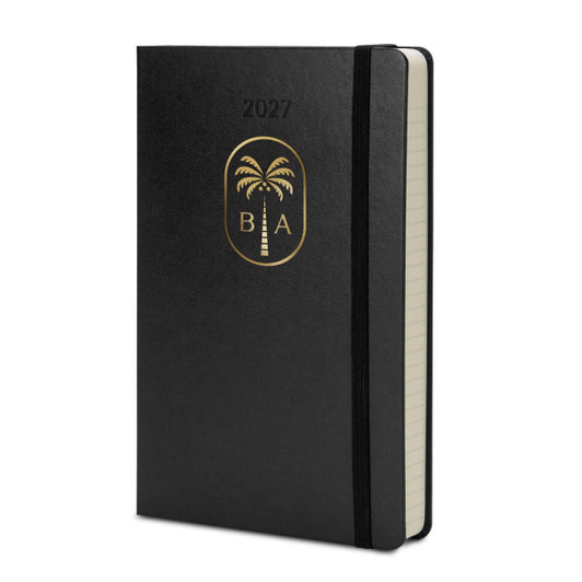 A black Moleskine 2027 planner with a gold palm tree emblem and a matching elastic band.