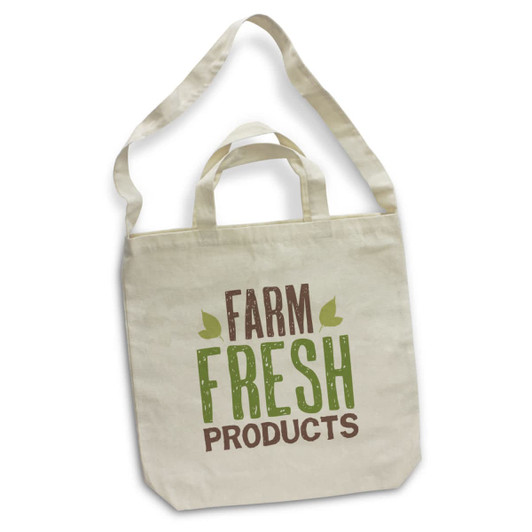 A cream cotton shoulder tote bag with green and brown printed text, featuring a logo on the front.