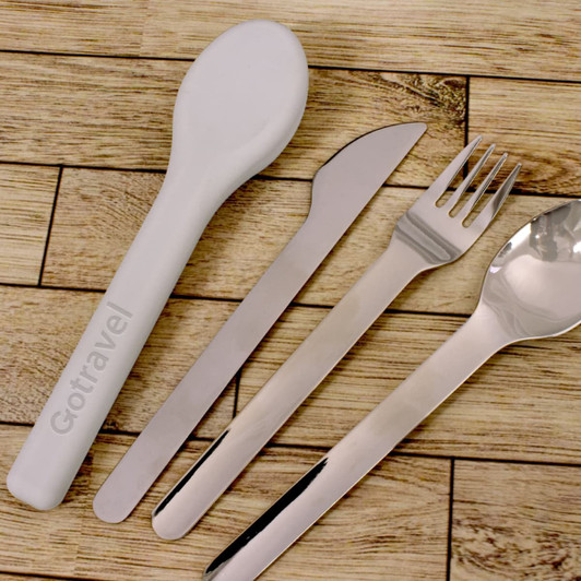 A travel cutlery set featuring a white spoon and stainless steel fork, knife, and dessert spoon, with a logo present.