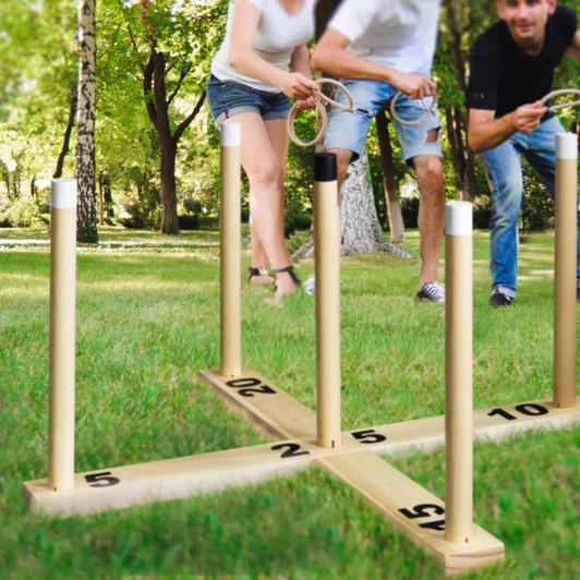 A wooden ring toss game with numbered posts in a grassy area, featuring players ready to toss rings.