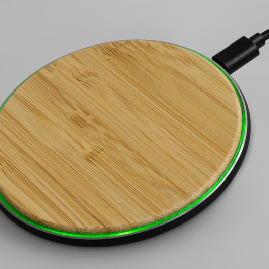A bamboo wireless fast charger with a green LED ring, featuring a circular design and black base.