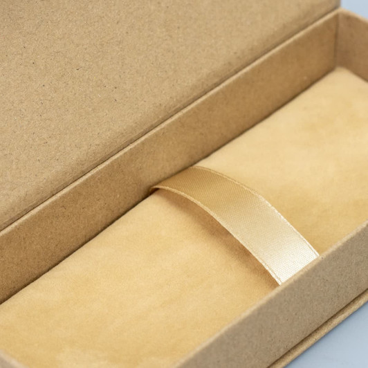 A kraft gift box with a soft interior and a gold ribbon, suitable for pen packaging.