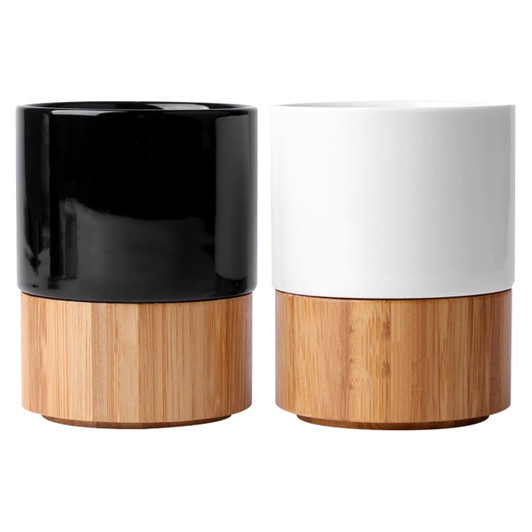 A black and a white ceramic mug on a bamboo base, showcasing a sleek, modern design. Each mug has a distinct colour.