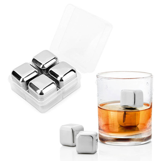 A drink bottle sits beside a glass containing amber liquid and shiny silver whiskey ice cubes in a transparent case.