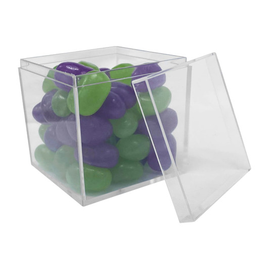 A clear cube container filled with green and purple jelly beans. The lid is partially open.