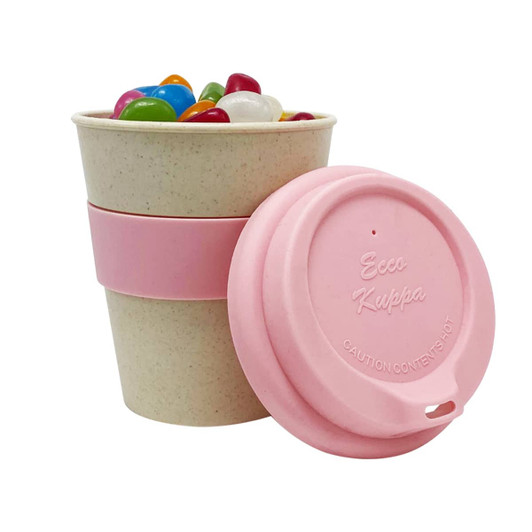 An 8oz bamboo cup in a beige colour with a pink lid and sleeve, filled with colourful jelly beans.