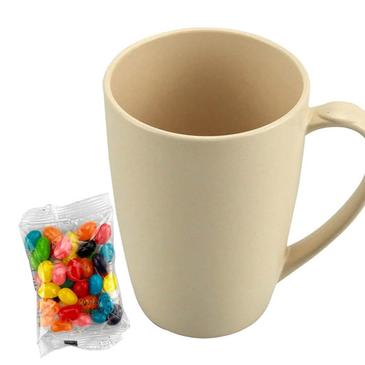 A beige bamboo mug with a handle alongside a bag of colourful jelly beans. The mug features a logo.