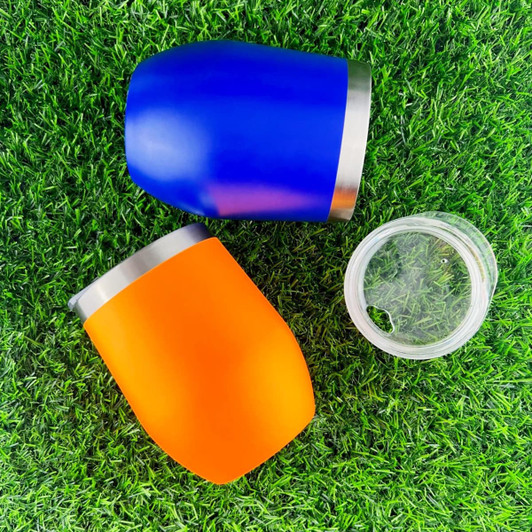 A drink bottle set featuring a blue and an orange travel mug with stainless steel accents, resting on green grass.