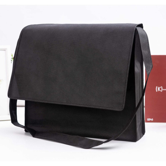 A black non-woven flap satchel with a shoulder strap and a smooth surface. It features a logo.