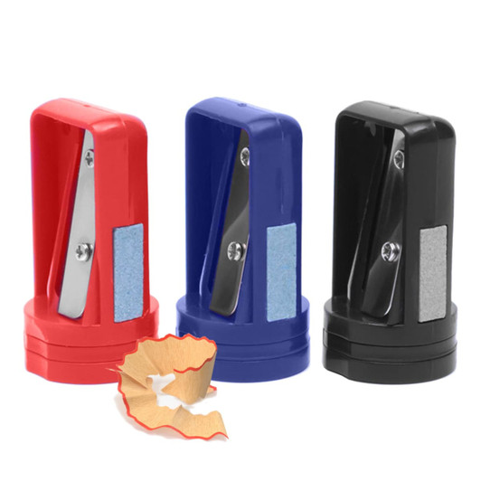 A set of three pencil sharpeners in red, blue, and black, with a wooden pencil shavings in front.