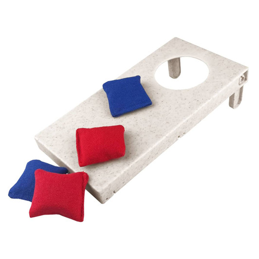 A wheat straw cornhole board in white with red and blue bean bags. The board features a circular hole for gameplay.