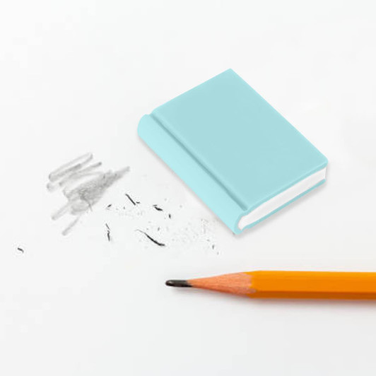 A light blue book-shaped rubber eraser beside pencil marks and a sharpened orange pencil on a white surface.