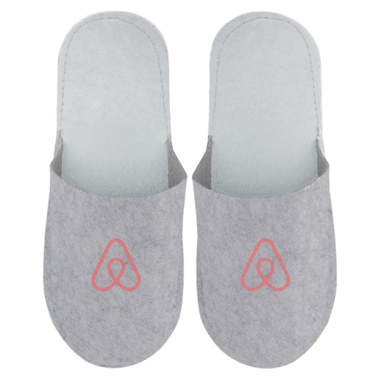 Grey felt slippers featuring a logo on the front, designed for comfort and cosy wear.