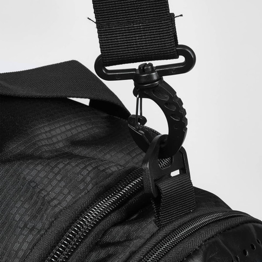 A close-up of a black duffle bag strap with a metal clip attachment. The bag has a textured surface.