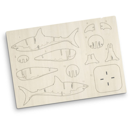 A plywood model kit featuring shark pieces, outlined for assembly, in natural wood colour. Includes a branding logo.