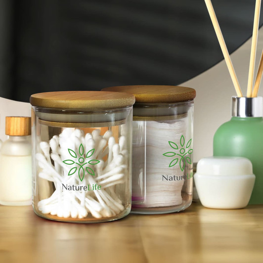 Round glass storage canisters with wooden lids, containing cotton tips and other items, with a logo present.