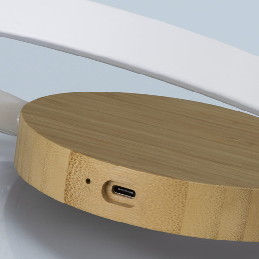 A round wireless charging station in natural bamboo, featuring a USB-C port on its base.