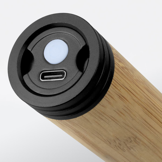 A bamboo torch featuring a USB-C charging port and a control button on the top. It has a sleek, natural wooden finish.