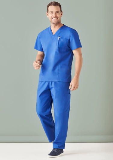 A man wearing a blue unisex scrub top and cargo pants, standing against a neutral background. The outfit includes a pocket.