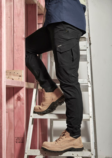 Men's lightweight outdoor cargo pants in black, featuring multiple pockets, worn while climbing a ladder.