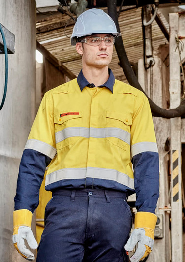 A man in a yellow and navy spliced work shirt with reflective stripes, wearing a hard hat and safety glasses.