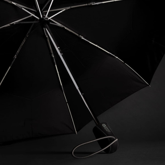 A black umbrella with a sleek design and a handle featuring a logo. The canopy is open, revealing its structure.