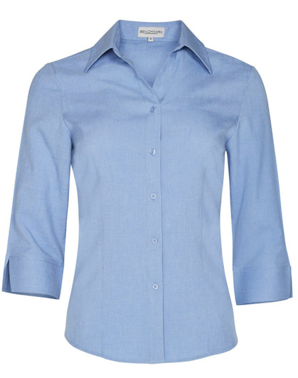 A light blue women's 3/4 sleeve shirt with a collared neckline and buttons, featuring a logo on the label.