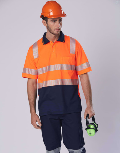 An orange and navy work polo shirt with reflective stripes, worn by a man holding hearing protection, against a neutral background.