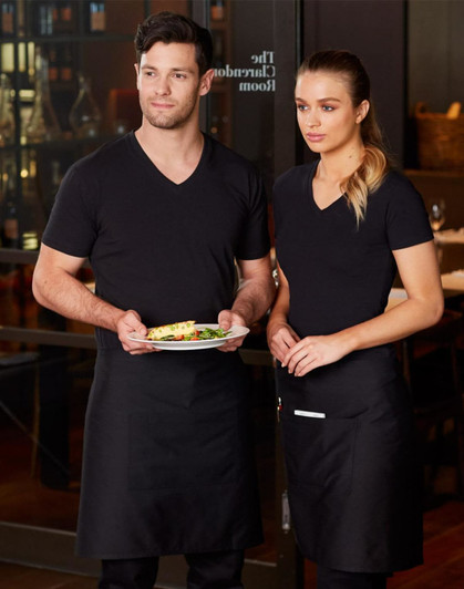 Two individuals wear black short waist aprons over black tops, standing with a plate of food in a restaurant setting.