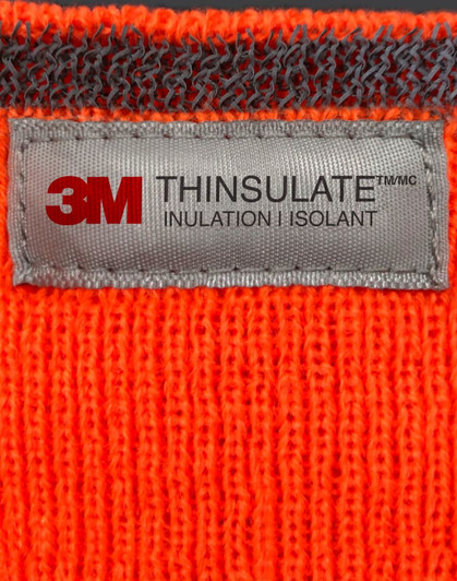An orange Thinsulated cuff beanie with a grey label featuring branding and care information.