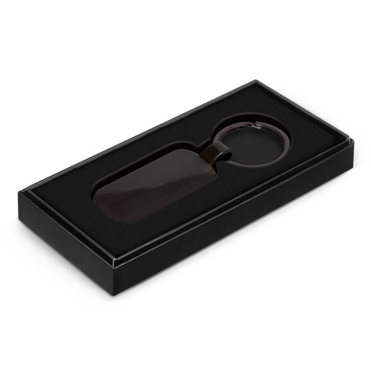 A Taurus key ring in a black box with an elegant design, featuring a sleek, dark-hued key ring.