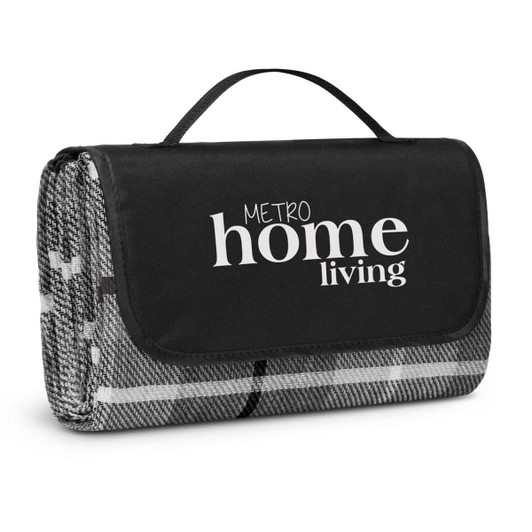 A folded picnic blanket with a black carrying handle, featuring a grey and white pattern and a logo.