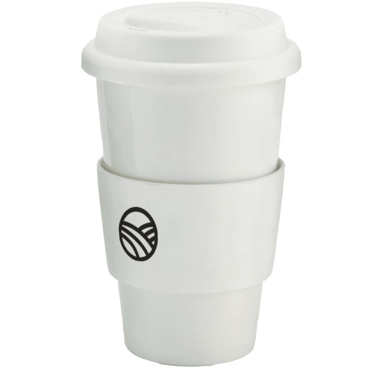A ceramic coffee mug in white with a black logo and a silicone sleeve for grip.