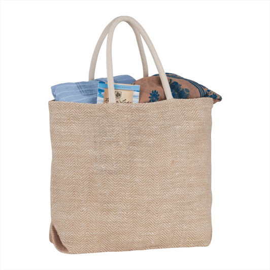 A herringbone-patterned jute tote in beige, filled with a blue and patterned fabric, featuring two handles and a logo.