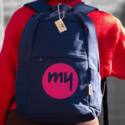 A navy backpack with a large pink logo, featuring multiple compartments and a tag attached. Perfect for carrying a laptop.
