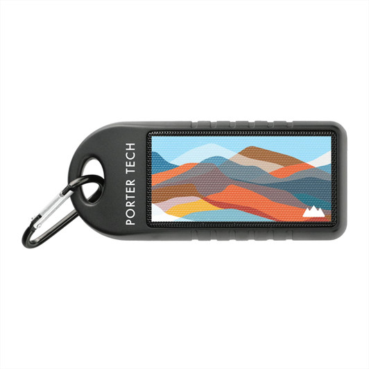 A portable speaker with a black casing and a vibrant mountain landscape design, featuring a carabiner for attachment.