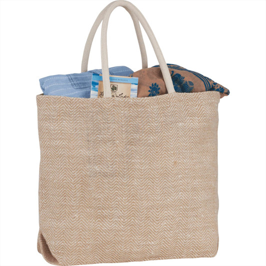 Herringbone jute tote in natural colour, featuring two handles and filled with folded fabric items. Includes a logo.