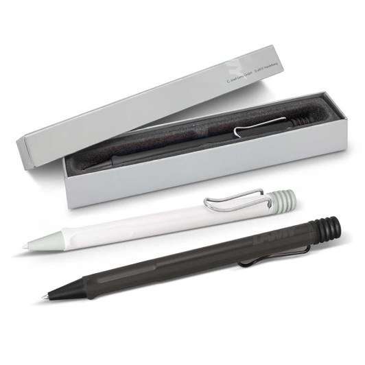 A collection of Lamy Safari pens in black, green, and white, displayed in a box with a soft interior.