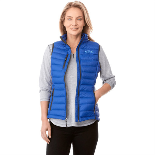 A woman models a vibrant blue down vest with a zippered front, featuring side pockets and a logo.