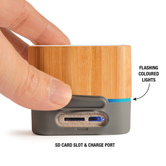 A bamboo Bluetooth speaker featuring a grey base, an SD card slot, a charge port, and flashing coloured lights.