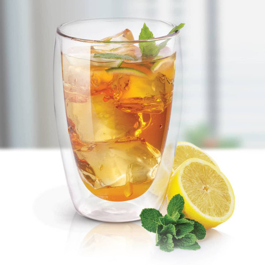 A double wall glass filled with iced tea, garnished with mint leaves, next to a slice of lemon. Features a logo.