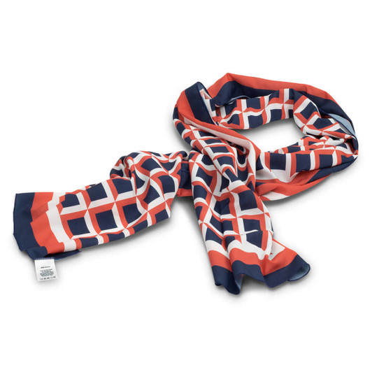 A patterned scarf in navy blue, orange, and white, featuring a geometric design. It has a logo on one side.
